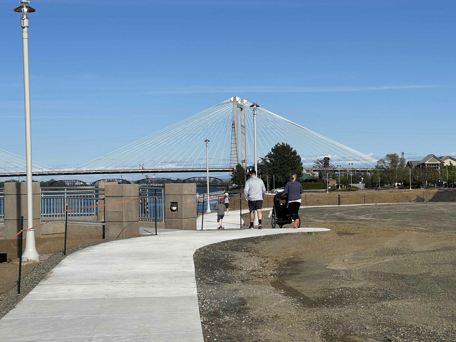 A family walking on a new section of the Clover Island Riverwalk Trail, added during a 2021/2022 project.