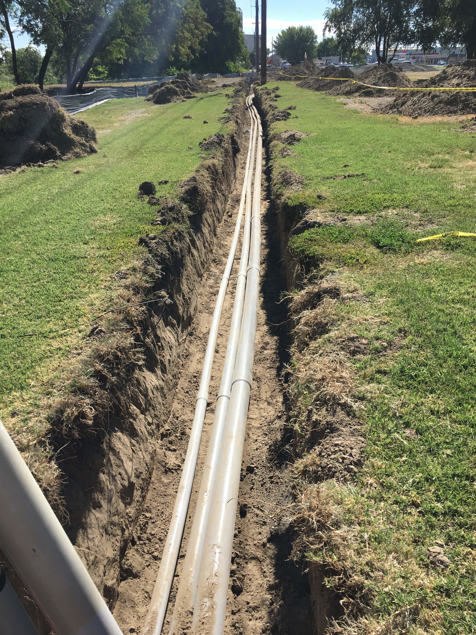 Utility conduits laid in bottom of open trench.