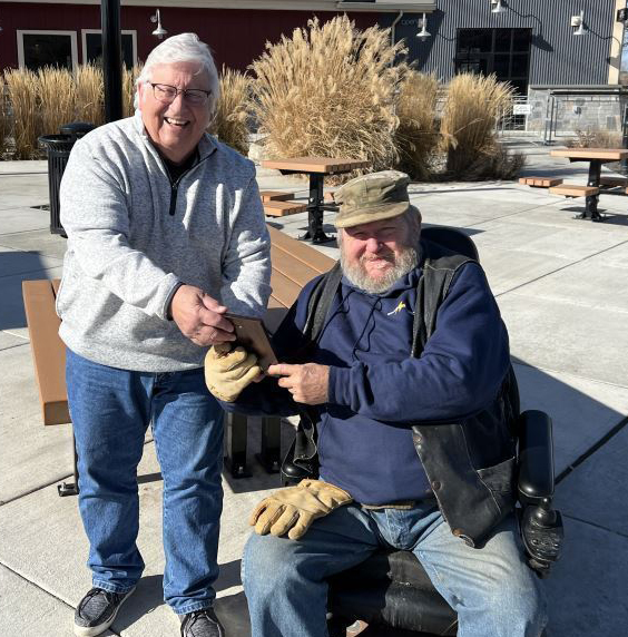 Port Commission President Skip Novakovich presents Columbia Gardens Wine & Artisan Village neighbor and volunteer watchman, James Cox, with the 2022 Friend of the Port award.