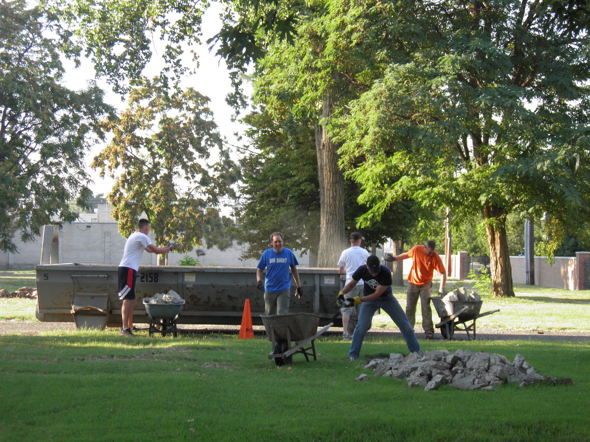 Community members help remove debris before redevelopment.