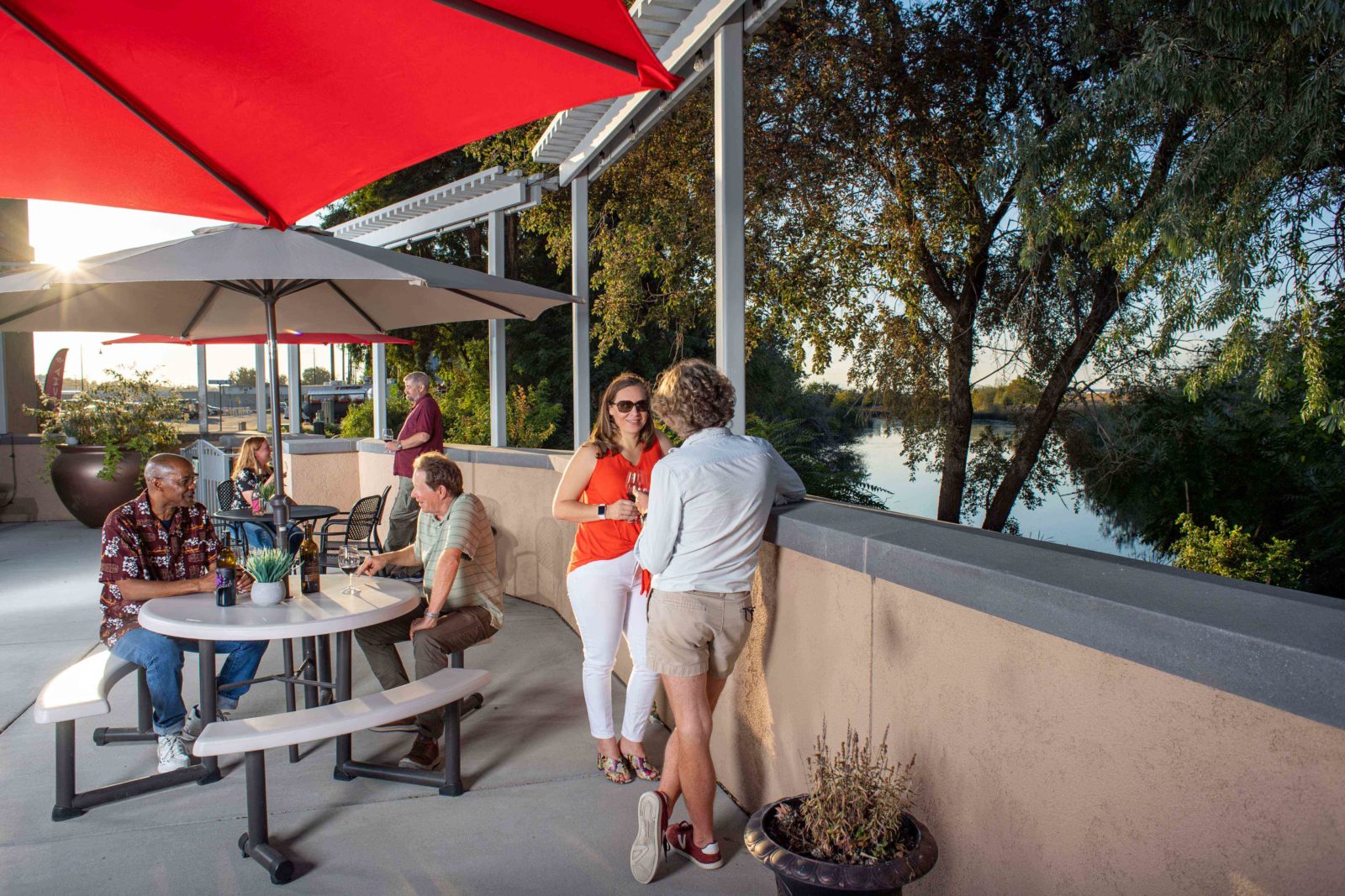 Friends sipping wine and taking in the waterfront views from one of the outdoor patios.