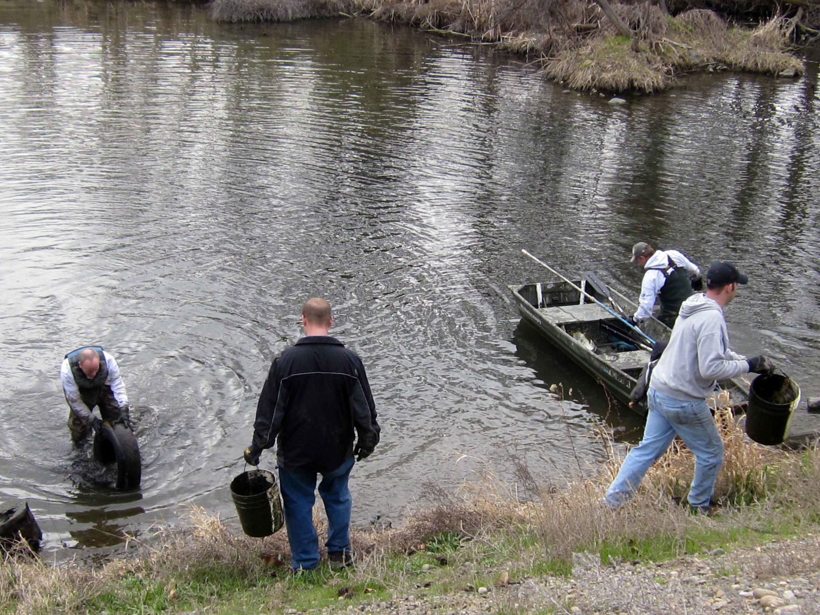 Community members hauling debris out of the pond at The Willows.