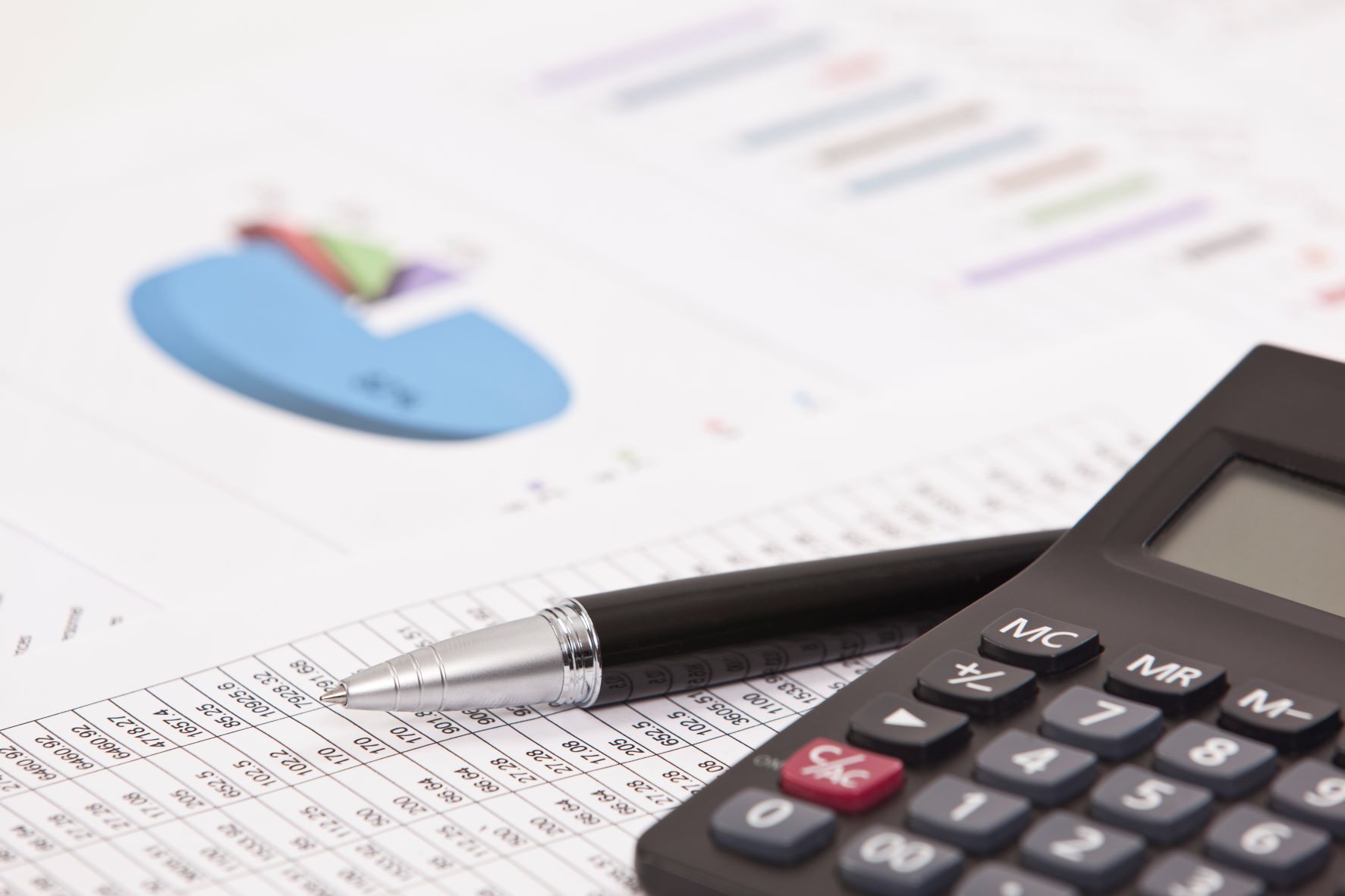 Photo showing calculator, pen and financial papers.