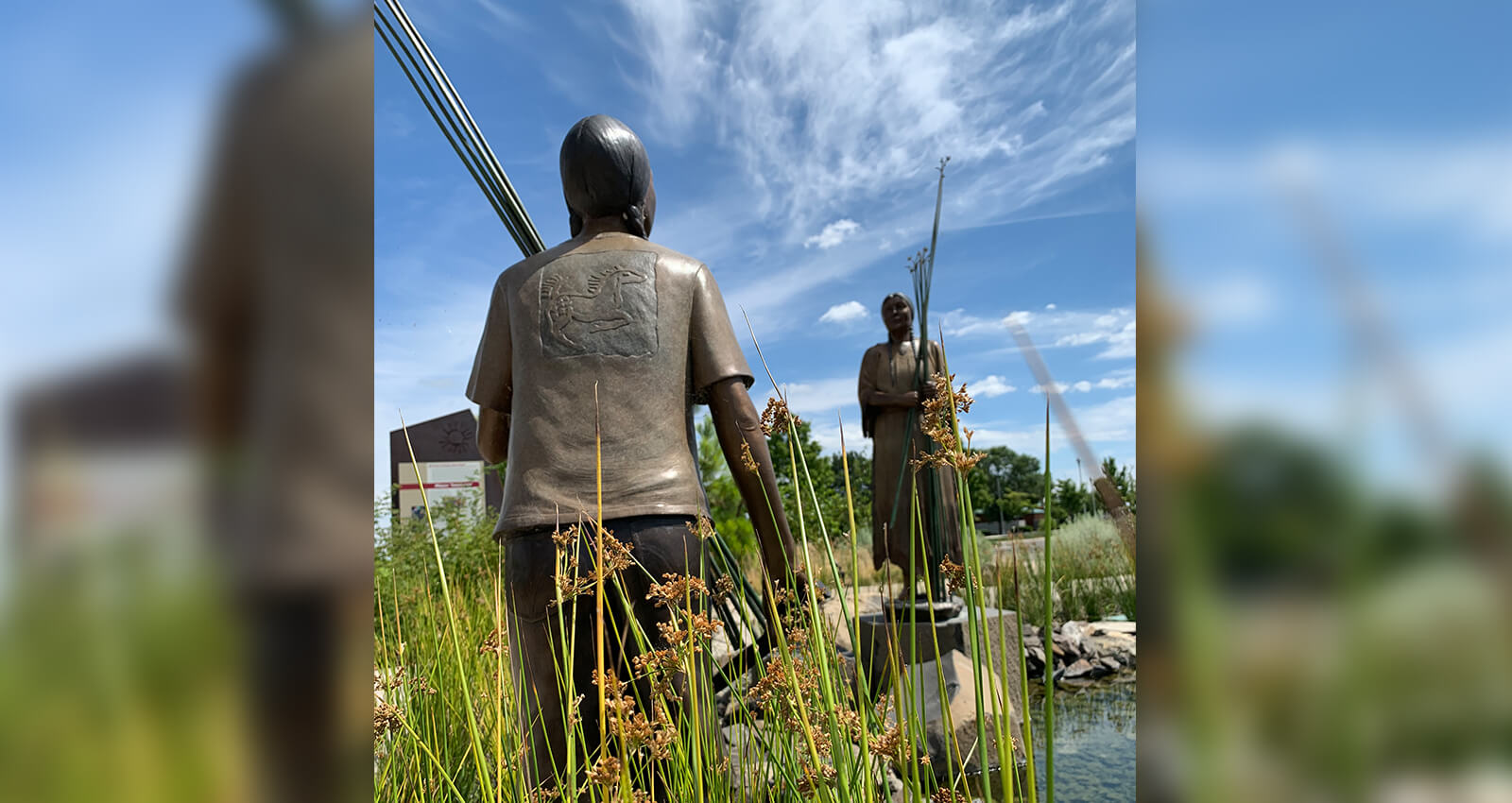 Two bronze statues with Tule reeds at The Gathering Place.